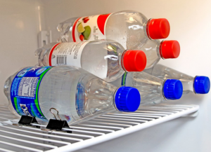 Use binder clips to keep bottles from rolling in fridge