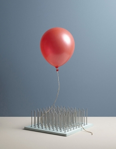 A balloon awaiting a slow death above a plinth of pins|In Anxious Anticipation Aaron Tilley