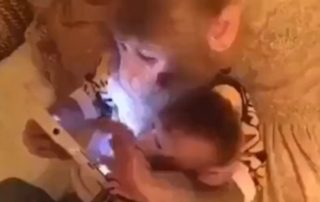 The older 'father' monkey can be seen scrolling through the tablet