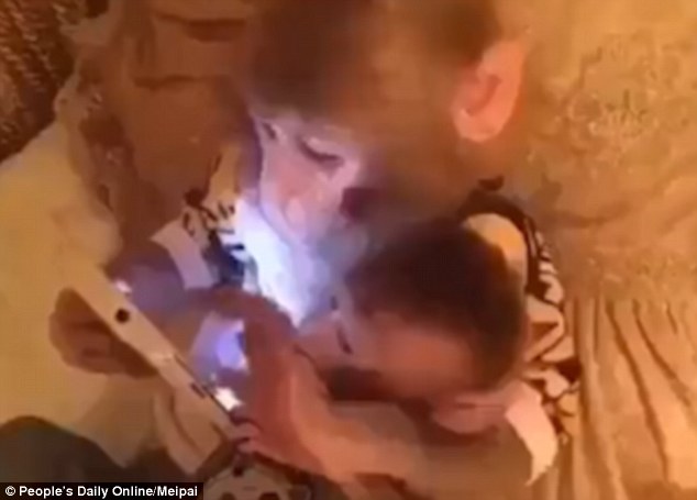 The older 'father' monkey can be seen scrolling through the tablet